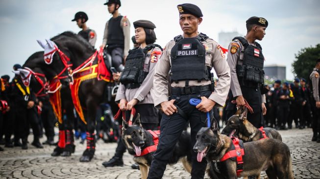 Polisi membawa anjing pelacak saat mengikuti apel Gelar Pasukan Operasi Lilin 2022 di Kawasan Monas, Jakarta, Kamis (22/12/2022). [ANTARA FOTO/Rivan Awal Lingga].