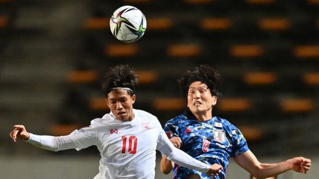 Penyerang Myanmar Win Naing Tun (Kiri) berebut bola dengan gelandang Jepang pada pertandingan Kualifikasi Grup F Piala Dunia 2022 di Fukuda Denshi Arena, Chiba, pada 28 Mei 2021. [AFP]