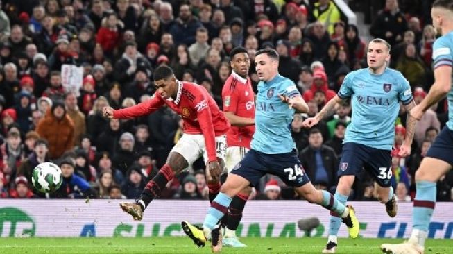 Striker Inggris Manchester United Marcus Rashford (kiri) menembak dan mencetak gol kedua bagi timnya pada pertandingan sepak bola putaran keempat Piala Liga Inggris antara Manchester United dan Burnley, di Old Trafford, di Manchester, pada 21 Desember 2022. Oli SCARFF/AFP