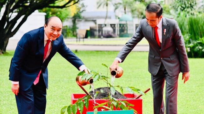 Presiden Joko Widodo atau Jokowi bersama Presiden Republik Sosialis Vietnam Nguyen Xuan Phuc menanam pohon Merawan atau "hopea odorata" di halaman samping Istana Kepresidenan Bogor, Kamis (22/12/2022). [Foto: Laily Rachev - Biro Pers Sekretariat Presiden]