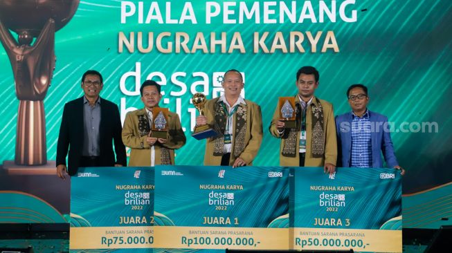 Wakil Direktur Utama BRI Catur Budi Harto (kiri) didampingi Direktur Kepatuhan BRI Ahmad Solichin  Lutfiyanto (kiri) foto bersama para pemenang Desa Brilian saat malam puncak Nugraha Karya Desa Brilian 2022 di Menara BRILian, Jakarta, Kamis (22/12/2022). [Suara.com/Alfian Winanto]