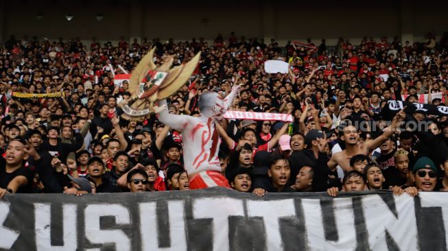 Suporter Indonesia membentangkan spanduk terkait Tragedi Kanjuruhan saat pertandingan sepak bola Grup A Piala AFF 2022 antara Indonesia dan Kamboja di Stadion Utama Gelora Bung Karno (SUGBK), Jakarta Pusat, Jumat (23/12/2022). [Suara.com/Alfian Winanto]