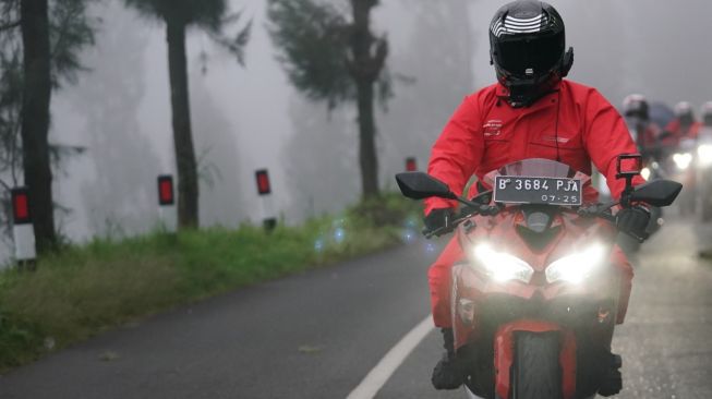 Bawa jas hujan saat touring sehingga badan terlindungi dari kondisi cuaca [PTPL].