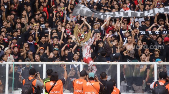 Suporter Indonesia membentangkan spanduk terkait Tragedi Kanjuruhan saat pertandingan sepak bola Grup A Piala AFF 2022 antara Indonesia dan Kamboja di Stadion Utama Gelora Bung Karno (SUGBK), Jakarta Pusat, Jumat (23/12/2022). [Suara.com/Alfian Winanto]