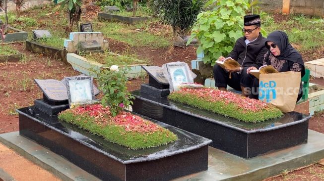 Haji Faisal dan Dewi Zuhriati ziarah ke makam Vanessa Angel dan Bibi Ardiansyah, Jumat (23/12/2022) [Suara.com/Adiyoga Priyambodo]