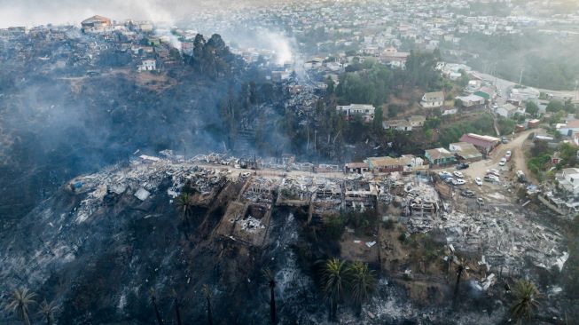  Pemandangan udara rumah-rumah yang hancur akibat kebakaran hutan yang melanda perbukitan Vina del Mar, di Wilayah Valparaiso, Chili, Jumat (23/12/2022). [JAVIER TORRES/AFP]