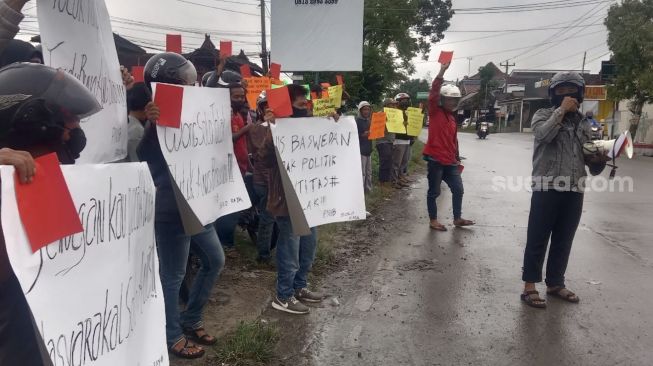 Warga yang tergabung dalam forum Masyarakat Solo Raya, melakukan aksi menolak kedatangan Anies Baswedan di Kota Solo. Penolakan itu dilakukan dengan membentangkan poster bernada penolakan di Kawasan Kelurahan Klodran, Kabupaten Karangannyar, Minggu (25/12/2022). [Suara.com/Budi Kusumo]