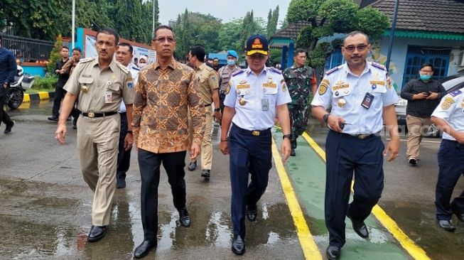 Penjabat (Pj) Gubernur DKI Jakarta, Heru Budi Hartono, (batik) melalukan sidak ke lokasi uji kendaraan bermotor (KIR) di Unit Pengelola Pengujian Kendaraan Bermotor (UPPKB) Ujung Menteng, Cakung, Jakarta Timur, pada Senin (26/12/2022).