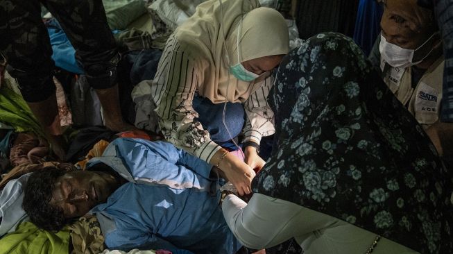 Sejumlah Imigran Etnis Rohingya mendapatkan perawatan medis di lokasi penampungan sementara di SMP Negeri 2 Curei, Kecamatan Muara Tiga, Kabupaten Pidie, Aceh, Senin (26/12/2022). [ANTARA FOTO/Joni Saputra].