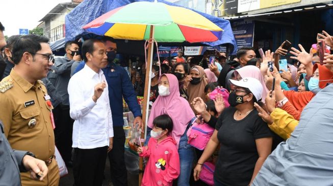 Presiden Joko Widodo (Jokowi) dan Gubernur Jabar Ridwan Kamil di Pasar Baru, Kabupaten Subang, Jawa Barat, Selasa (27/12/2022). [Foto: Kris - Biro Pers Sekretariat Presiden]