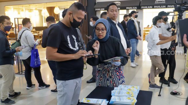 Petugas dari Kementerian ATR/BPN mengajak pengunjung Sarinah untuk berpartisipasi dalam acara Peringatan Hari Ibu Kementerian ATR/BPN di Sarinah, Jakarta Pusat, Selasa (27/12/2022). [Suara.com/Alfian Winanto]