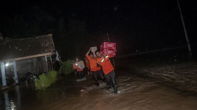 Relawan membawa paket bantuan makanan di Desa Idaman, Pandeglang, Banten, Selasa (27/12/2022). [ANTARA FOTO/Muhammad Bagus Khoirunas].