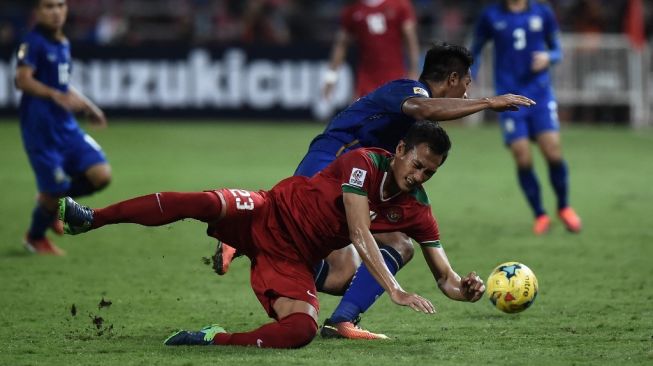 Bek Timnas Indonesia, Hansamu Yama Pranata (tengah) jatuh setelah dijegal pemain Thailand dalam laga final Piala AFF 2016 antara Thailand vs Indonesia di Stadion Rajamangala di Bangkok pada 17 Desember 2016.LILLIAN SUWANRUMPHA/AFP.