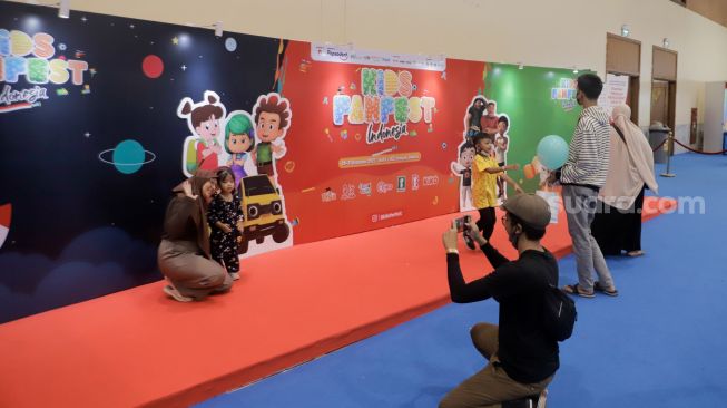 Sejumlah anak berswafoto saat menghadiri acara Kids FanFest Indonesia 2022 di Hall A, Jakarta Convention Center (JCC), Senayan, Jakarta, Jumat (30/12/2022). [Suara.com/Alfian Winanto]