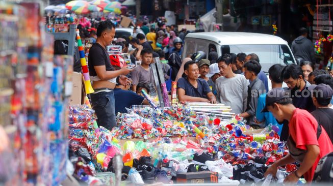 Pedagang kembang api melayani pembeli di Pasar Asemka, Jakarta Barat, Jumat (30/12/2022). [Suara.com/Alfian Winanto]