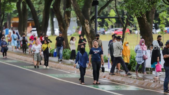 Pengunjung beraktivitas saat berwisata di Taman Mini Indonesia Indah (TMII), Jakarta Timur, Sabtu (31/12/2022). [Suara.com/Alfian Winanto]