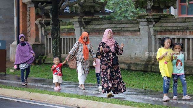 Pengunjung beraktivitas saat berwisata di Taman Mini Indonesia Indah (TMII), Jakarta Timur, Sabtu (31/12/2022). [Suara.com/Alfian Winanto]