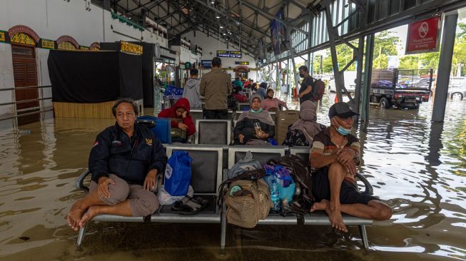 Sejumlah penumpang menanti keberangkatan kereta api yang mengalami keterlambatan akibat banjir yang merendam jalur kereta api maupun stasiun di Stasiun Tawang, Semarang, Jawa Tengah, Sabtu (31/12/2022). [ANTARA FOTO/Aji Styawan].