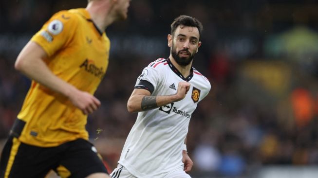 Gelandang Manchester United Bruno Fernandes mengejar bola selama pertandingan pekan ke-18 Liga Inggris antara Wolves vs Manchester United di stadion Molineux di Wolverhampton, Inggris tengah pada 31 Desember 2022.ADRIAN DENNIS / AFP.