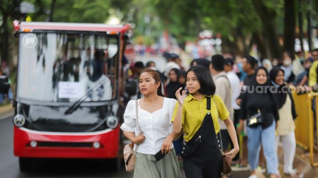 Pengunjung beraktivitas saat berwisata di Taman Mini Indonesia Indah (TMII), Jakarta Timur, Sabtu (31/12/2022). [Suara.com/Alfian Winanto]