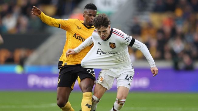 Bek Wolverhampton Wanderers Nelson Semedo (kiri) menarik baju gelandang Manchester United Alejandro Garnacho (kanan) selama pertandingan pekan ke-18 Liga Inggris 2022-2023 antara Wolves vs Manchester United di stadion Molineux di Wolverhampton, Inggris tengah pada 31 Desember 2022 .ADRIAN DENNIS / AFP.