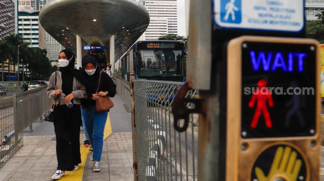 Pekerja melintas saat jam pulang kerja di Kawasan Sudirman - Thamrin, Jakarta Pusat, Senin (2/1/2023). [Suara.com/Alfian Winanto] 