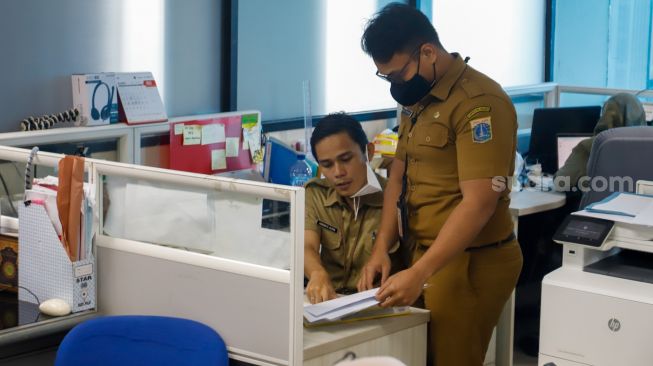 Pegawai Badan Kepegawaian Daerah (BKD) DKI Jakarta menyelesaikan pekerjaannya di kantor Balai kota Jakarta, Senin (2/1/2023). [Suara.com/Alfian Winanto]