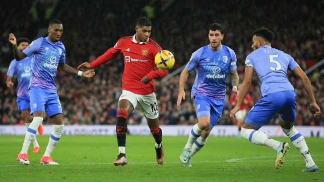 Striker Manchester United Marcus Rashford (tengah) bersaing dengan bek Bournemouth Lloyd Kelly (kanan) selama pertandingan pekan ke-19 Liga Inggris antara Manchester United vs Bournemouth di Old Trafford di Manchester, barat laut Inggris, pada 3 Januari 2023.Lindsey Parnaby / AFP.