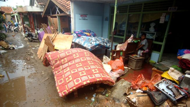 Warga membersihkan barang-barangnya yang kotor akibat terendam banjir bandang di Jatibarang Kidul, Brebes, Jawa Tengah, Kamis (5/1/2023). [ANTARA FOTO/Oky Lukmansyah]