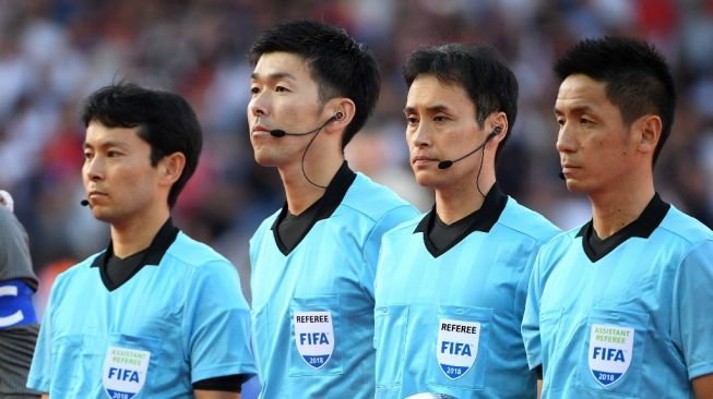 Ofisial pertandingan Jepang, termasuk wasit Hiroyuki Kiumura, asisten wasit Hiroshi Yamauchi, asisten wasit Jun Mihara dan ofisial keempat Araki Yusuke (kedua dari kiri) berbaris untuk berfoto jelang pertandingan persahabatan Internasional antara Inggris vs Kosta Rika di Elland Road, Leeds di Inggris utara pada 7 Juni 2018. Inggris memenangkan pertandingan 2-0.Paul ELLIS / AFP.