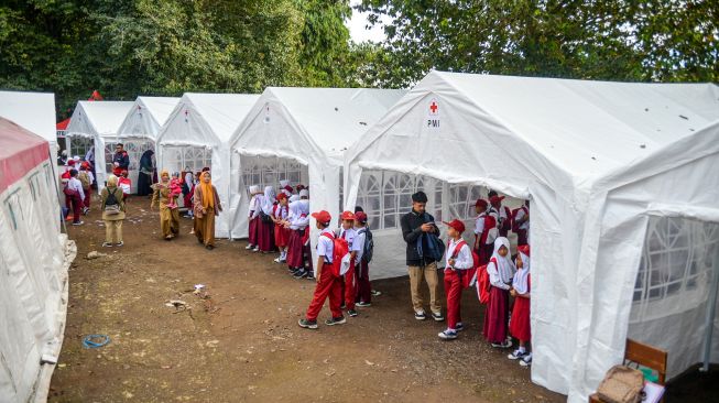 Sejumlah siswa bersiap untuk melakukan kegiatan belajar mengajar di tenda sekolah darurat di SDN Citamiang, Sarongge, Kabupaten Cianjur, Jawa Barat, Senin (9/1/2023). [ANTARA FOTO/Raisan Al Farisi/hp]