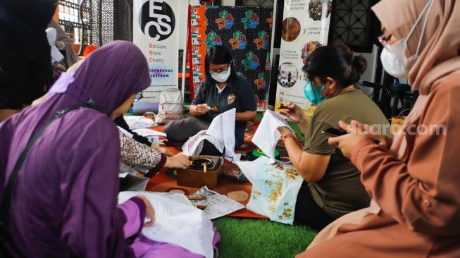 Peserta belajar proses membuat batik di Rawamangun, Jakarta Timur, Senin (9/1/2023). [Suara.com/Alfian Winanto]