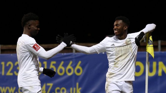 Striker Arsenal Eddie Nketiah (kanan) melakukan selebrasi dengan Bukayo Saka (kiri) setelah mencetak gol kedua timnya selama pertandingan putaran ketiga Piala FA 2022-2023 antara Oxford United vs Arsenal di Stadion Kassam di Oxford, barat London, pada Januari 9, 2023.ADRIAN DENNIS / AFP.