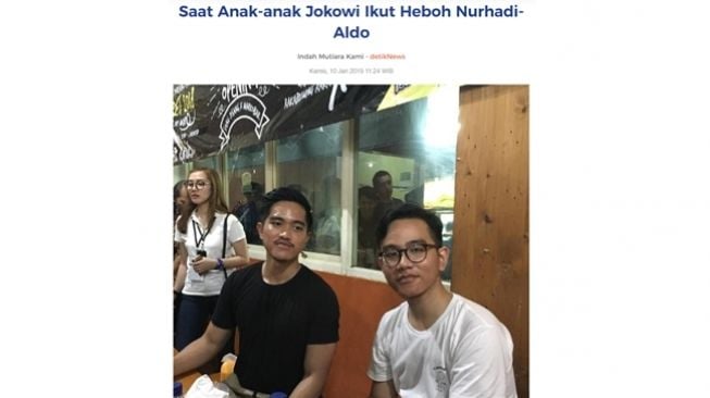 Tangkapan layar artikel Detik.com dengan foto Kaesang Pangarep memakai kaos hitam polos tanpa logo palu arit bersama Gibran Rakabuming Raka. (Turnbackhoax.id)