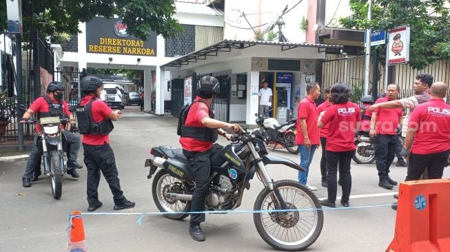 Petugas kepolisian melakukan pengamanan saat hendak membawa tersangka kasus peredaran sabu Irjen Pol Teddy Minahasa untuk diserahkan ke Kejaksaan Tinggi DKI Jakarta, Rabu (11/1/2023). [Suara.com/M. Yasir)