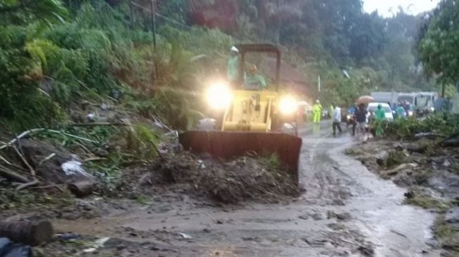 Operator alat berat membersihkan material longsor yang menutupi ruas jalan Tomohon Manado pada beberapa waktu lalu [ANTARA/HO-BPJN Sulut]