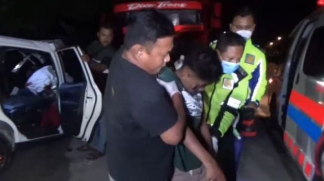 Petugas Polres Ngawi dibantu warga mengevakuasi korban kecelakaan mobil  Honda Mobilio menabrak truk tronton di Ring Road Ngawi masuk Desa Kandangan Kabupaten Ngawi, Jawa Timur, Kamis (12/1/2022). (ANTARA/Louis Rika)