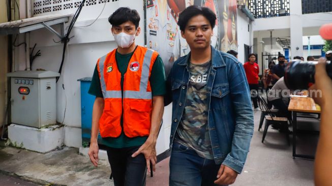 Aktor Revaldo Fifaldi dibawa petugas usai dihadirkan saat rilis kasus narkoba yang menjeratnya di Polda Metro Jaya, Jakarta, Jumat (13/1/2023). [Suara.com/Alfian Winanto]