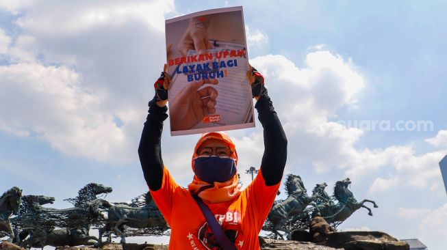 Massa aksi dari Partai Buruh dan beberapa serikat buruh lainnya menggelar aksi di Kawasan Patung Kuda Arjuna, Jakarta Pusat, Sabtu (14/1/2023). [Suara.com/Alfian Winanto]