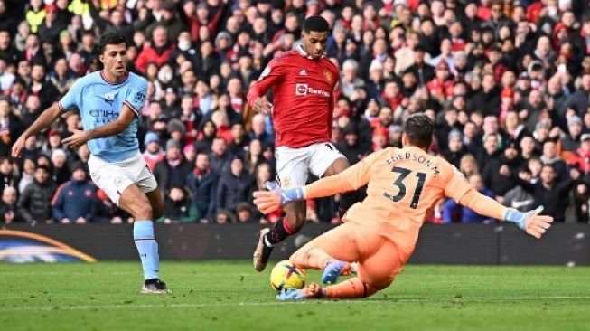 Kiper Manchester City Brasil Ederson (kanan) menyelamatkan gawangnya dari tembakan dari striker Inggris Manchester United Marcus Rashford selama pertandingan sepak bola Liga Premier Inggris antara Manchester United dan Manchester City di Old Trafford di Manchester, barat laut Inggris, pada 14 Januari 2023.Oli SCARFF/AFP