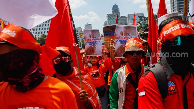 Massa aksi dari Partai Buruh dan beberapa serikat buruh lainnya menggelar aksi di Kawasan Patung Kuda Arjuna, Jakarta Pusat, Sabtu (14/1/2023). [Suara.com/Alfian Winanto]