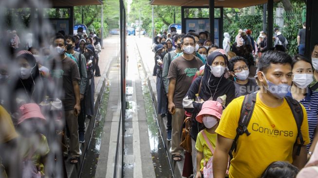 Warga saat menaiki bus tingkat Transjakarta dengan atap terbuka di Jakarta, Sabtu (14/1/2023). [Suara.com/Alfian Winanto]