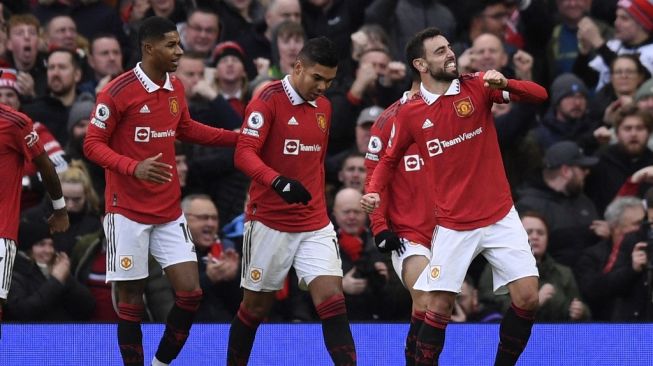 Striker Manchester United Marcus Rashford (kiri) memberi selamat kepada Bruno Fernandes (kanan) atas golnya selama pertandingan pekan ke-20 Liga Inggris antara Manchester United vs Manchester City di Old Trafford di Manchester, barat laut Inggris, pada 14 Januari 2023.Oli SCARFF/AFP