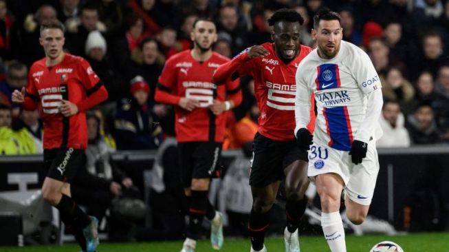 Pemain PSG Lionel Messi (kanan) ditempel penyerang Rennes Arnaud Kalimuendo saat menggiring bola dalam pertandingan Liga Prancis di Roazhon Park stadium, Rennes pada 16 Januari 2023. ANTARA/AFP/LOIC VENANCE