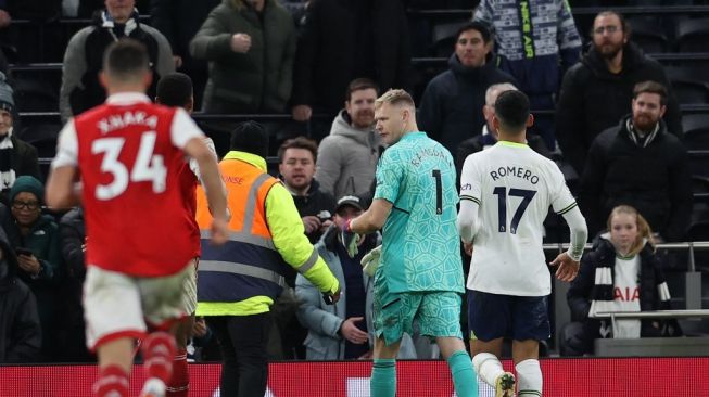 Seorang steward berusaha menenangkan penjaga gawang  Arsenal Aaron Ramsdale usai kepalanya didorong oleh striker Tottenham Richarlison setelah pertandingan pekan ke-20 Liga Inggris 2022-2023 antara Tottenham Hotspur vs Arsenal di Stadion Tottenham Hotspur di London, pada 15 Januari 2023. Arsenal memenangkan pertandingan 2-0.ADRIAN DENNIS / AFP.