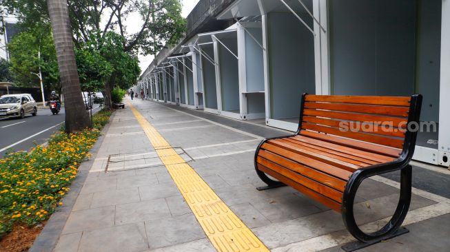 Warga melintas di dekat kios untuk pedagang kaki lima (PKL) di Jalan Penataran, kawasan Tugu Proklamasi, Jakarta Pusat, Selasa (17/1/2023).  [Suara.com/Alfian Winanto]