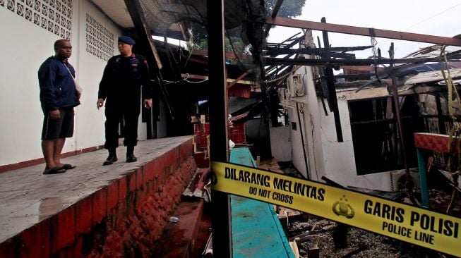 Sejumlah petugas kepolisian memeriksa kondisi sisa kebakaran di rumah dinas Kapolda Papua Irjen Mathius D Fakhiri di Distrik Jayapura Utara, Kota Jayapura, Papua, Selasa (17/1/2023). [ANTARA FOTO/Gusti Tanati].