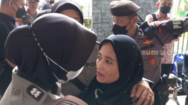 Polisi wanita (Polwan) mengamankan fans Ferdy Sambo, Syarifah setelah sempat menerobos ruang sidang. (Suara.com/Rakha)