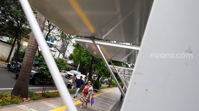 Warga melintas di dekat kios untuk pedagang kaki lima (PKL) di Jalan Penataran, kawasan Tugu Proklamasi, Jakarta Pusat, Selasa (17/1/2023).  [Suara.com/Alfian Winanto]