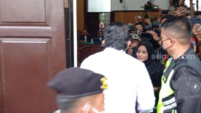 Polisi wanita (Polwan) mengamankan fans Ferdy Sambo, Syarifah setelah sempat menerobos ruang sidang. (Suara.com/Rakha)